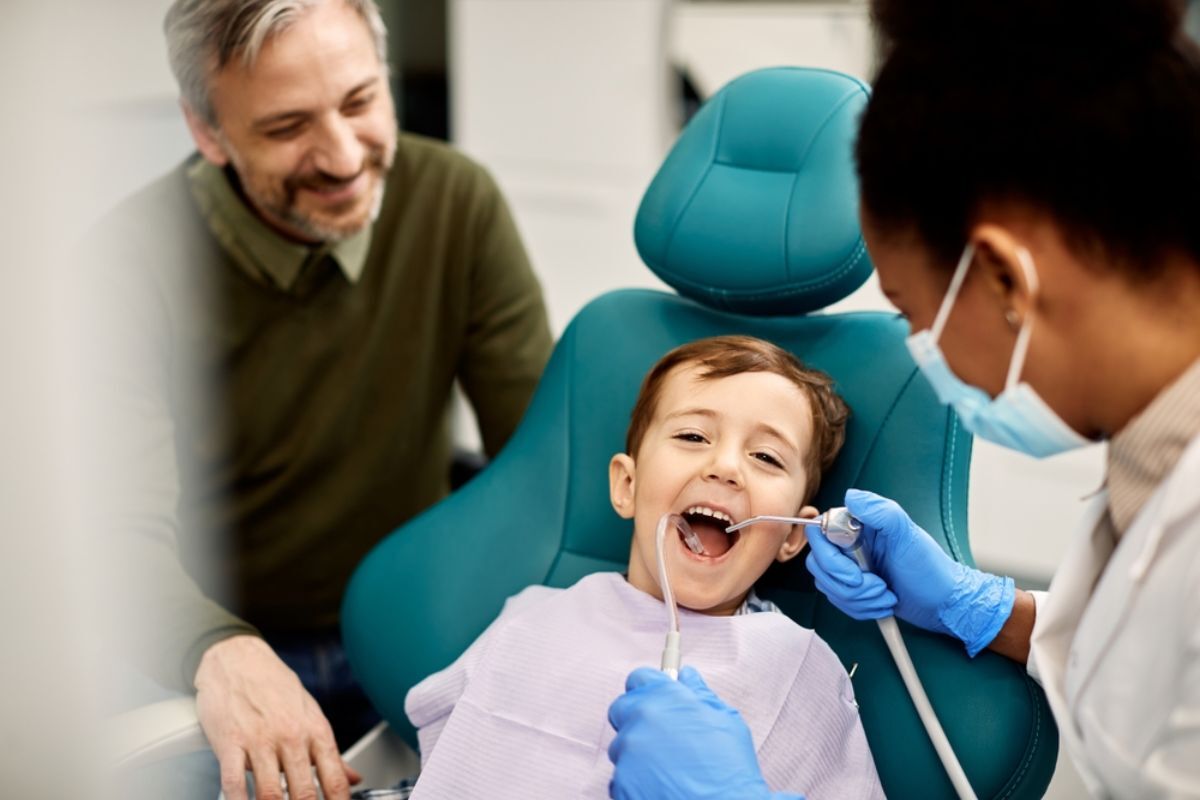 dentist performing a routine dental examination on a young child in a dental clinic.
