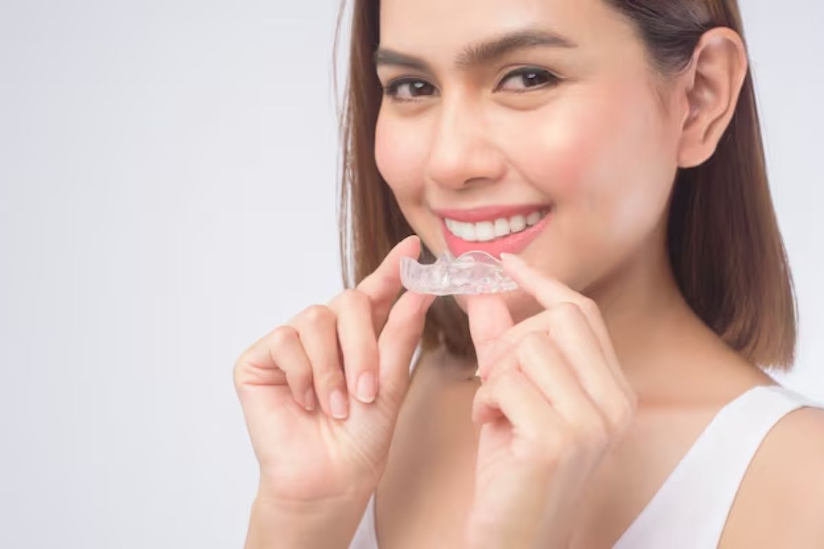 woman holding clear invisalign aligners before teeth straightening treatment
